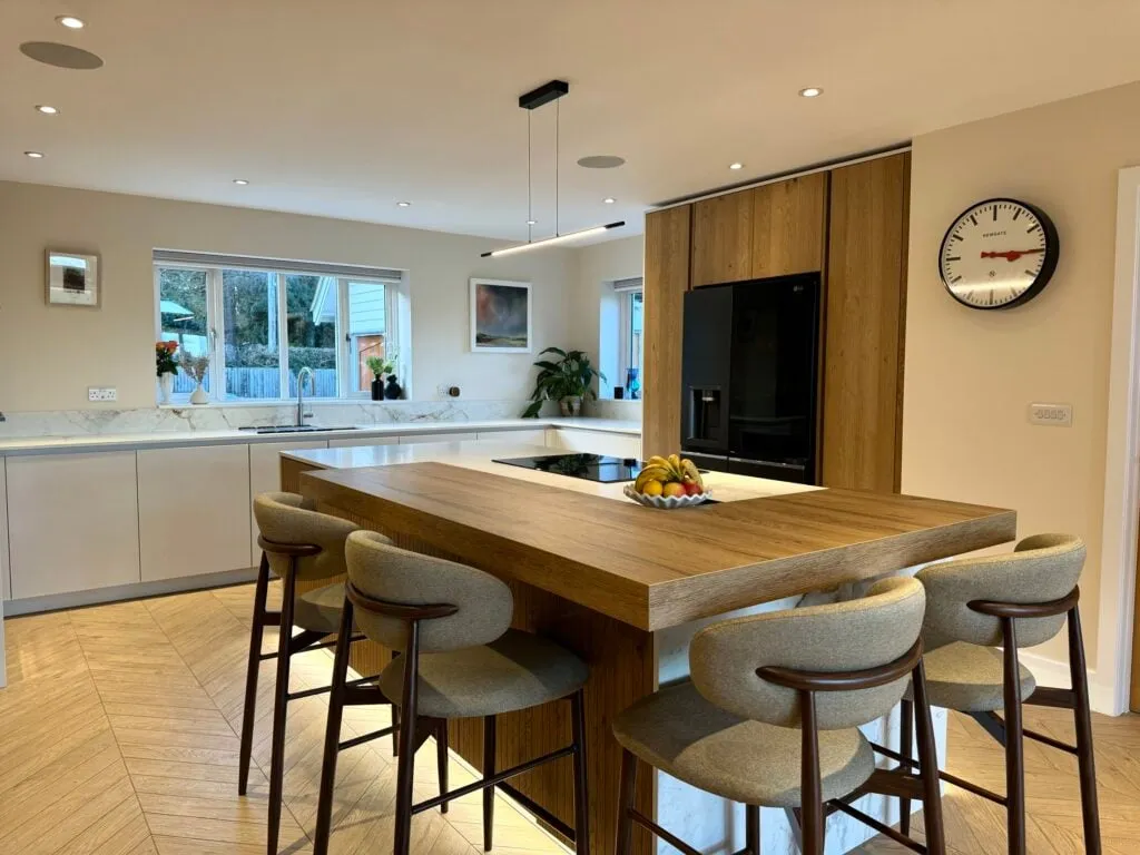Kitchen island design featuring fluted oak cabinetry, quartz worktops and integrated seating