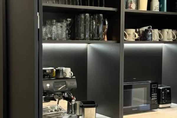 Close-up of a bespoke kitchen coffee station with quartz worktops and illuminated storage